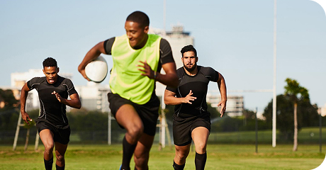Players running on the field with a football in hand during a game