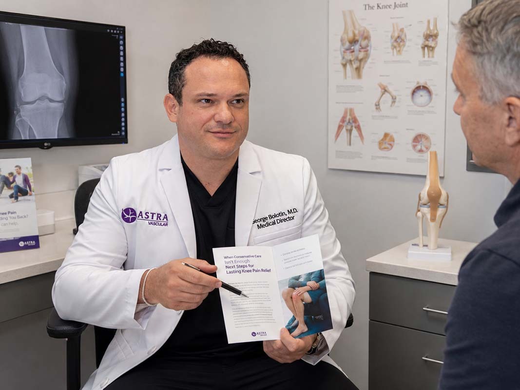 Knee pain specialist discussing GAE candidacy and non-surgical treatment options with a patient