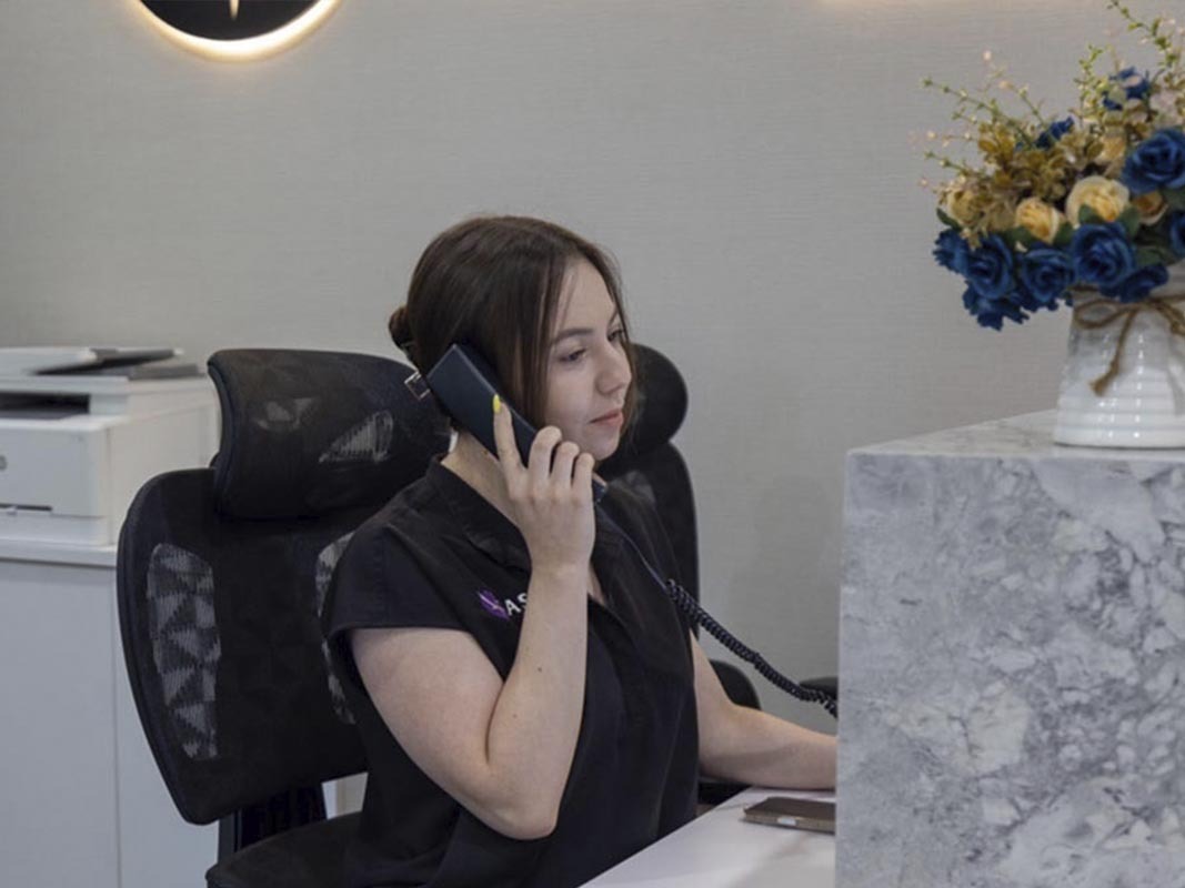 Astra Knee Pain Center front desk staff assisting a patient by phone with GAE insurance coverage in Brooklyn and the Bronx