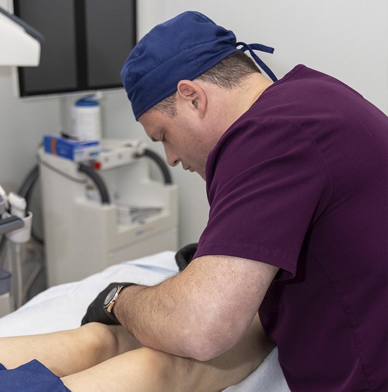 Knee pain specialist examining a patient for non-surgical knee pain treatment in Brooklyn and the Bronx